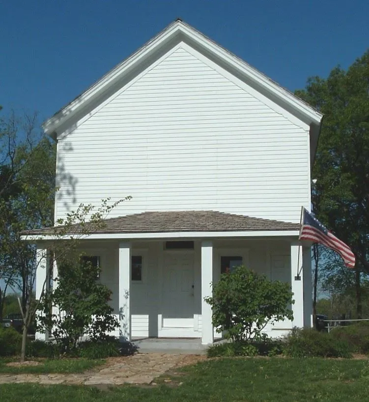 The white one-room Mt. Gilead School with its front porch and flag